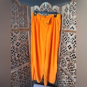 Orange wide leg trousers with zipper and button closure, featuring a relaxed fit